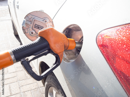 gas gun at a gas station refuels a car with gasoline photo