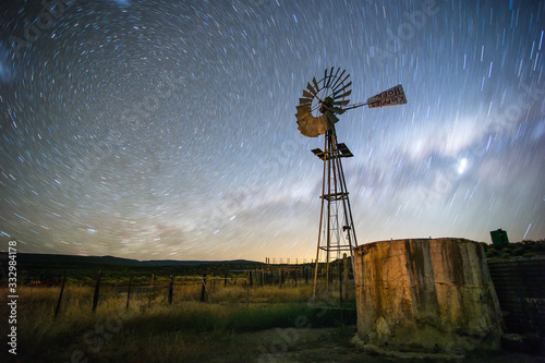 Wide angle image of a windmill / windpomp / windpump on a farm in the karoo with the blazing milkyway overhead