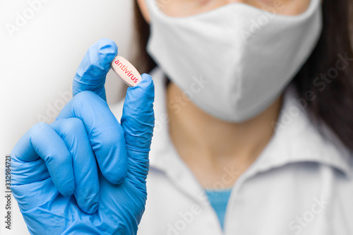 A pill in hand in blue gloves. Female is holding antivirus against coronavirus,2019-nCoV, SARS-nCov, COVID-2019 outbreaking.