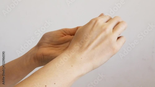 Female hands cleaning washing with sanitizer gel over bright gray background