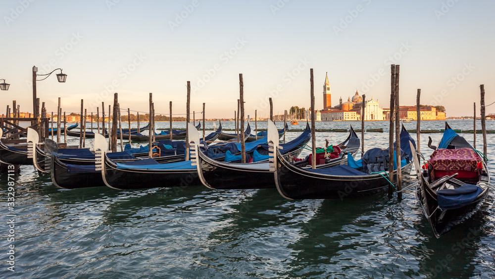 Gondolas moored by Saint Mark square with San Giorgio di Maggiore church, Venice