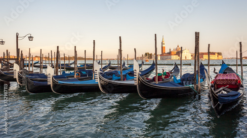 Gondolas moored by Saint Mark square with San Giorgio di Maggiore church, Venice © k_samurkas