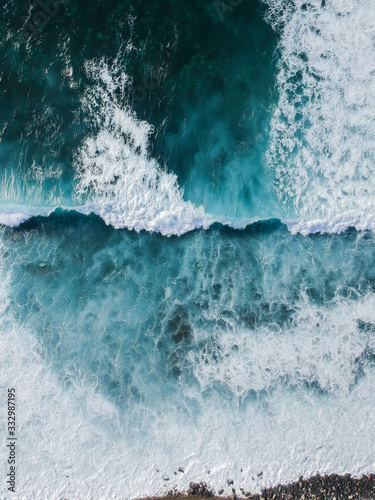 Leinwand Poster Aerial drone view of spashing waves in blue ocean