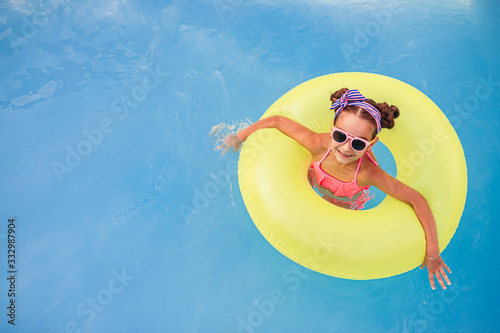 Cheerful girl with inflatable ring having fun in pool