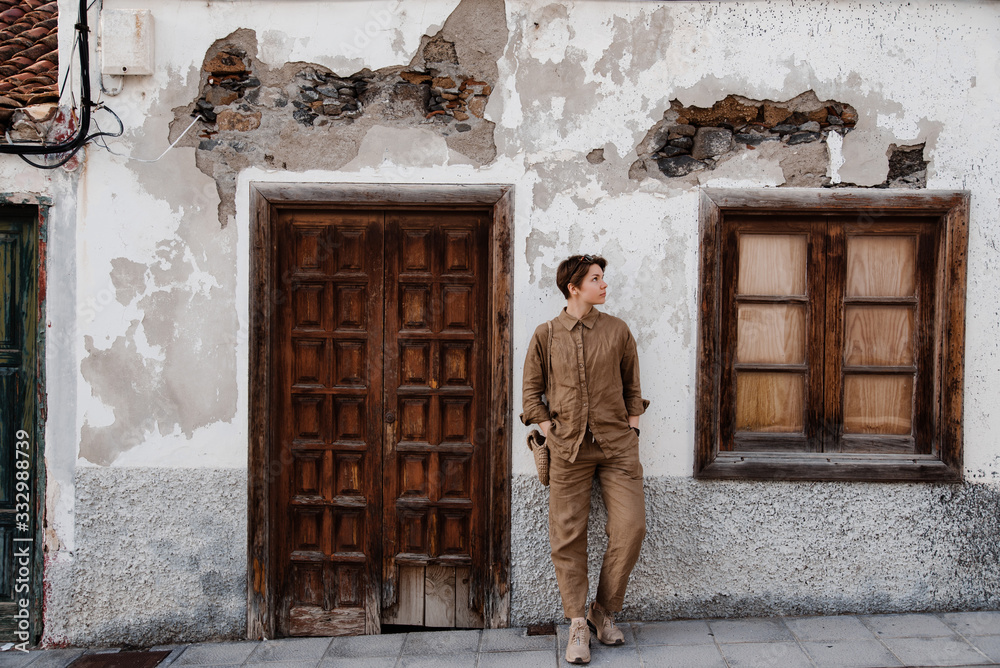 Stylish girl leaning on wall of old house. Stylish girl leaning on wall of old house.