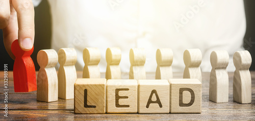 Man puts a leader at head of line of people. Project leadership. Appointment to a responsible post, strategic management planning. Distribution business optimization. Career promotion to leading post. photo
