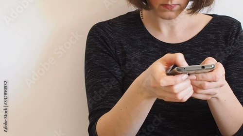 Young caucasian woman faceless in casual clothes using mobile phone
