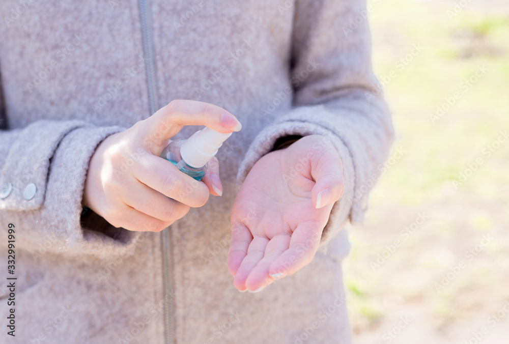 Woman's hands press a bottle with a disinfectant to her hands on the street. Macro shot and macro shot, Selective focus, Prevention by covid 19, Bacteria, healthcare concept