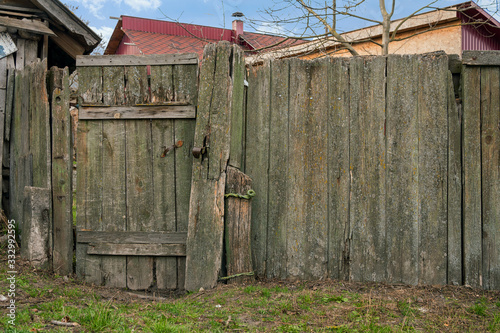 Rural Scene. Run-down wooden fence with wicket for entrance in yard of rural house. From weathered old boards. Close-up.