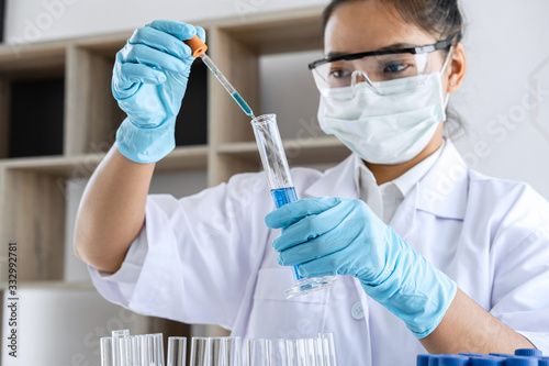 Biochemistry laboratory research  Chemist is analyzing sample in laboratory with equipment and science experiments glassware containing chemical liquid