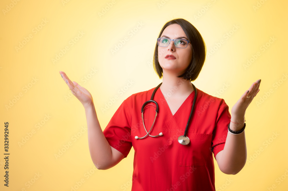 Beautiful woman doctor with stethoscope, wearing red scrubs with open arms looking up, side view