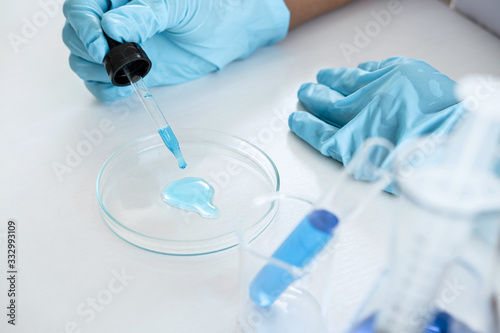 Biochemistry laboratory research, Chemist is analyzing sample in laboratory with equipment and science experiments glassware containing chemical liquid