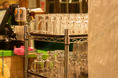 cafe interior, row of empty beer glasses on shelf in bar, upside down glasses in a cafe, bar equipment, 