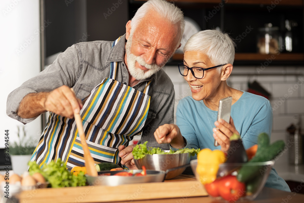 Senior couple shares a video call with their friends how prepare meal Senior couple shares a video call with their friends how prepare meal
