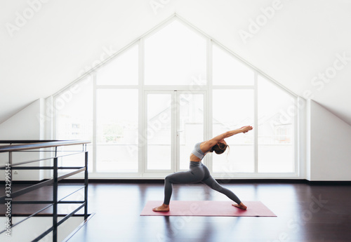 Beautiful young woman doing yoga postures in luxury apartment photo