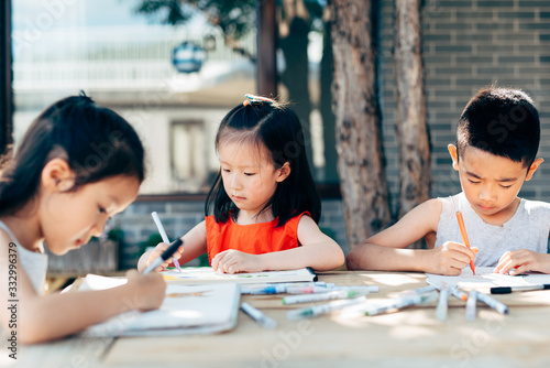 Kids drawing on a table outdoors photo