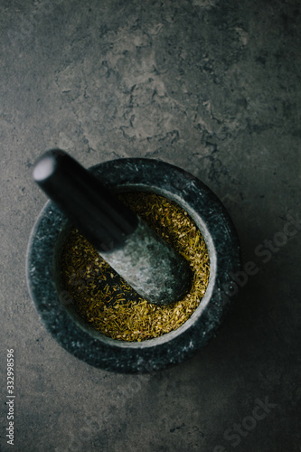 Spice mix in a dark mortar with pestle