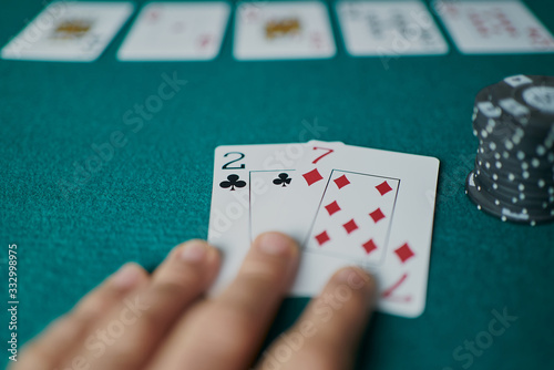 Fotografie Bad poker gamble or unlucky hand concept with player going all in with 2 and 7 (