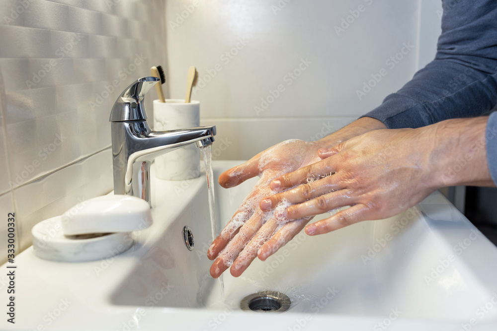 Hygiene concept. Washing hands with soap under the tap with water. Male hands and water in the bathroom. Hygiene concept. Washing hands with soap under the tap with water. Male hands and water in the bathroom.
