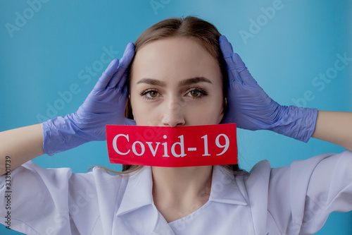 Doctor woman pointing to red paper with mesaage Coronavirus on blue background. World Health Organization WHO introduced new official name for Coronavirus disease named COVID-19 photo