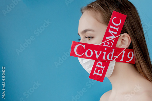 Doctor woman with surgical mask pointing to red paper with mesaage Coronavirus on blue background. World Health Organization WHO introduced new official name for Coronavirus disease named COVID-19 photo