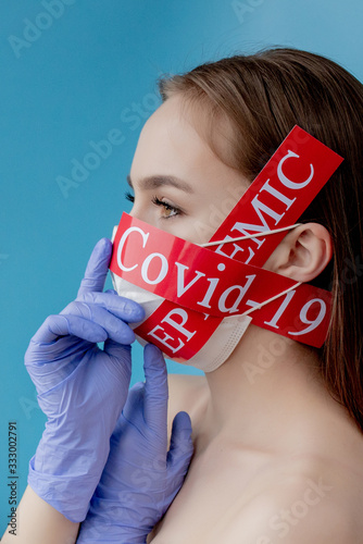 Doctor woman with surgical mask pointing to red paper with mesaage Coronavirus on blue background. World Health Organization WHO introduced new official name for Coronavirus disease named COVID-19 photo