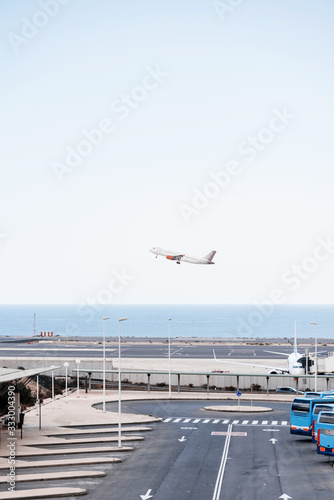 Plane flying at airport near ocean coastline. photo