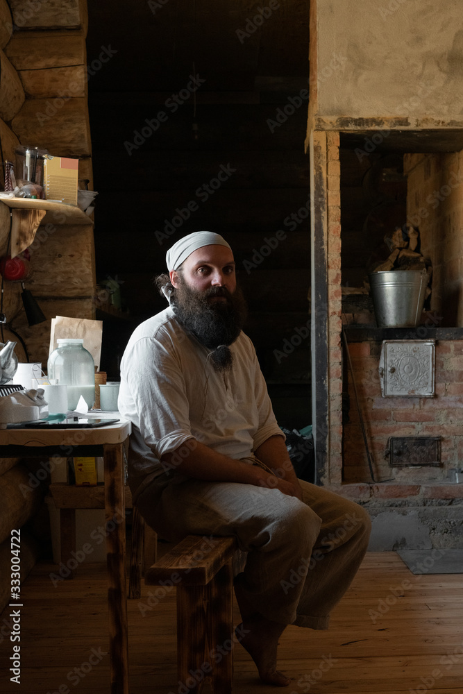 Man sitting in kitchen of rural log house Man sitting in kitchen of rural log house
