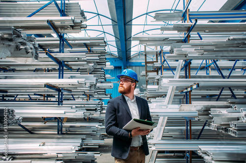 Worker standing with file in factory photo
