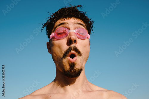 Man in swimming goggles summer vibrant portrait
