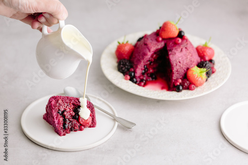 Pouring cream onto Summer Pudding, classic English dessert photo