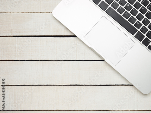 Workplace - laptop for remote work on a white wooden table. Freelance desktop for home or office. Background with copy space.