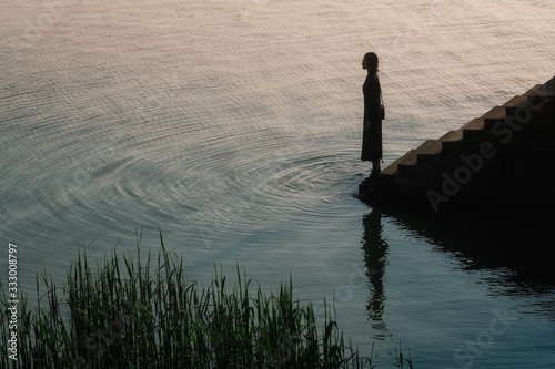 Woman standing by Lake Tai during sunset photo