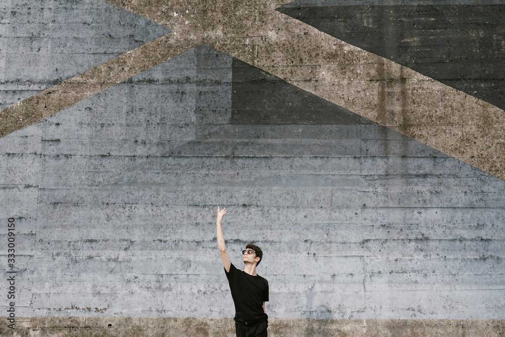 Young man dancing on urban background