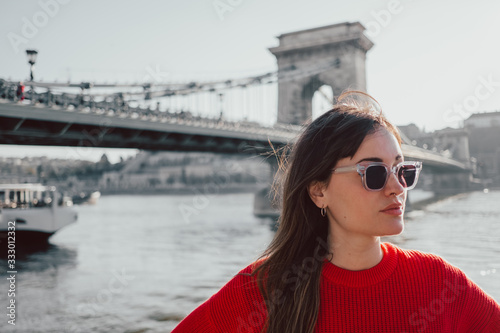 Portrait of woman in sunglasses with a bridge on her back