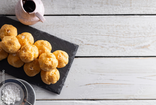 Fotografi Delicious profiteroles, cream puff filled with fresh cream with chocolate topping