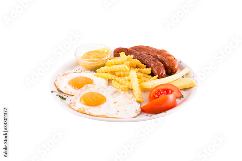 Grilled sausages with two eggs, tomatoes and french fries. Photo taken on a white background. Dish of Montenegrin cuisine. Suitable for the restaurant menu.