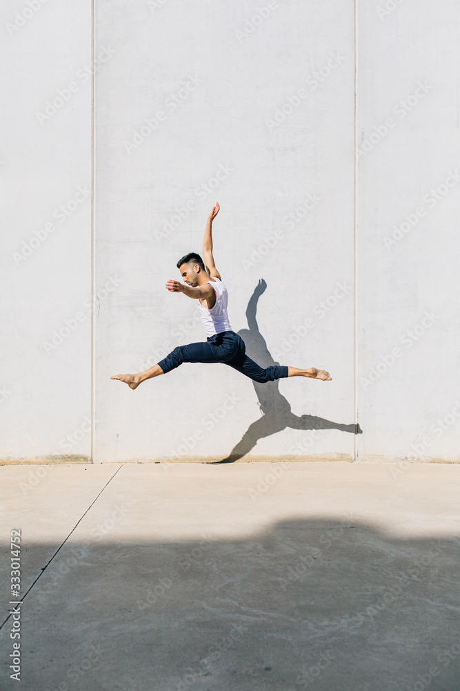 A dancer dancing in front of a concrete wall A dancer dancing in front of a concrete wall