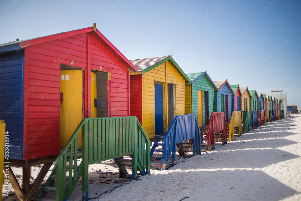 Naklejka premium Wide angle view of the colourful beach huts on Muizenberg Beach in Cape Town South Africa