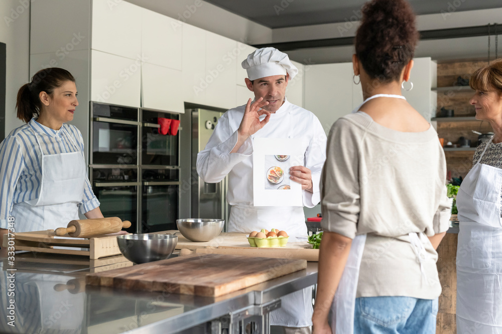 Chef explains recipes in a kitchen class Chef explains recipes in a kitchen class
