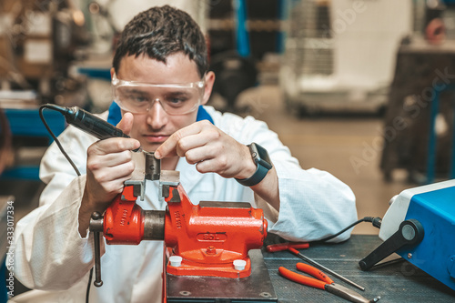 Obraz na plátně student of technical school on practical exam when working with vise and electri