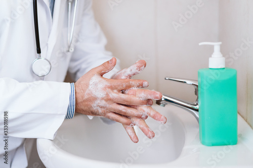 doctor man washing hands with disinfectant soap. Hygiene and Corona virus Covid-19 concept © Eva