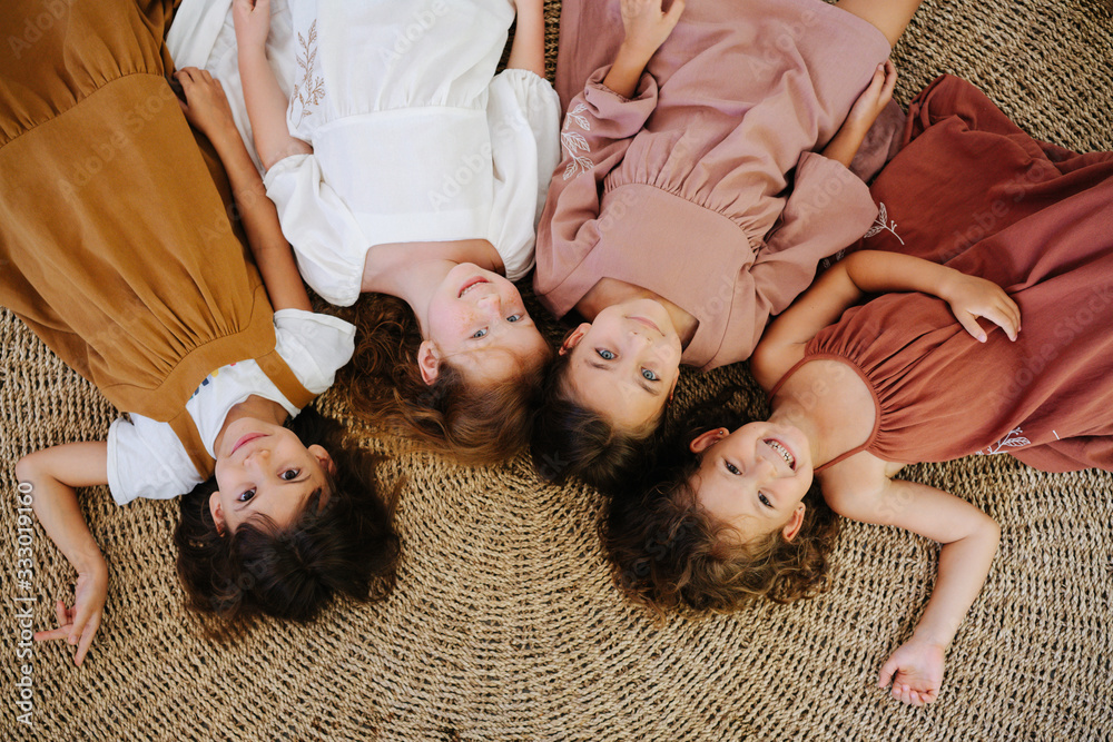 Overhead view of four little girls lying on the floor head to head