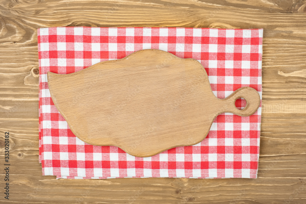 Red checkered tablecloth and wooden spoon for cooking and baking. Background with copy space. Horizontal. Red checkered tablecloth and wooden spoon for cooking and baking. Background with copy space. Horizontal.