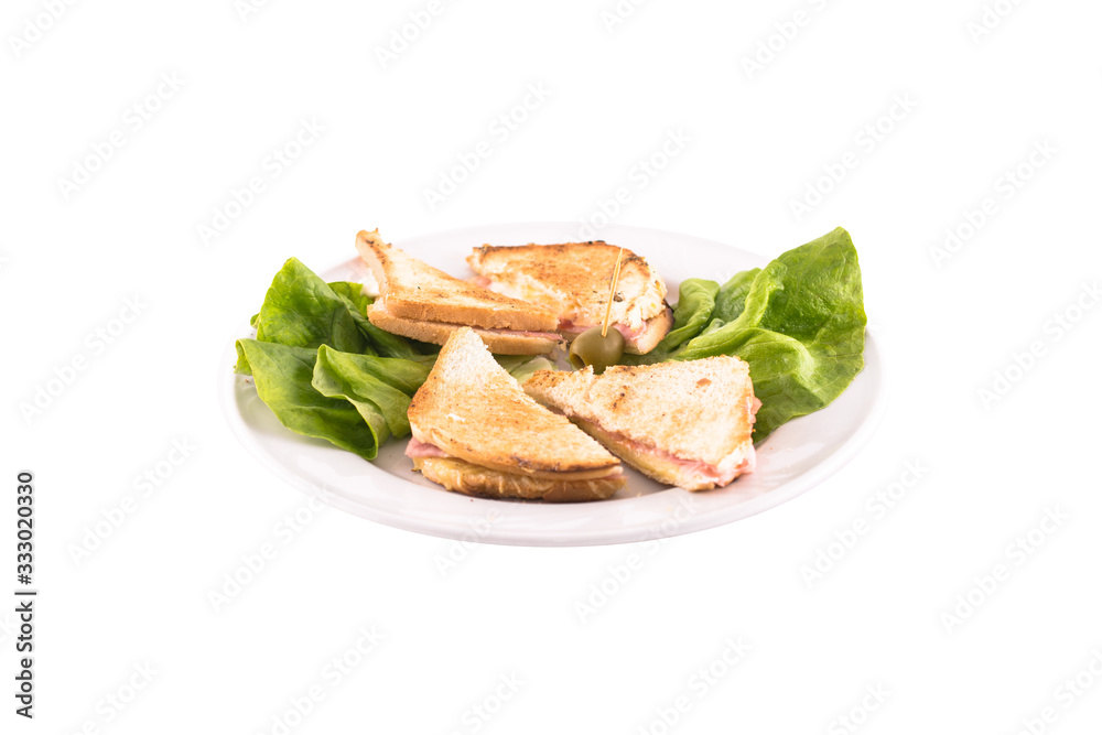 Ham and cheese sandwich decorated with green salad. Served on a white plate, melted on a white background. The photo is suitable for feeding mei restaurant. Dish of Montenegrin cuisine.