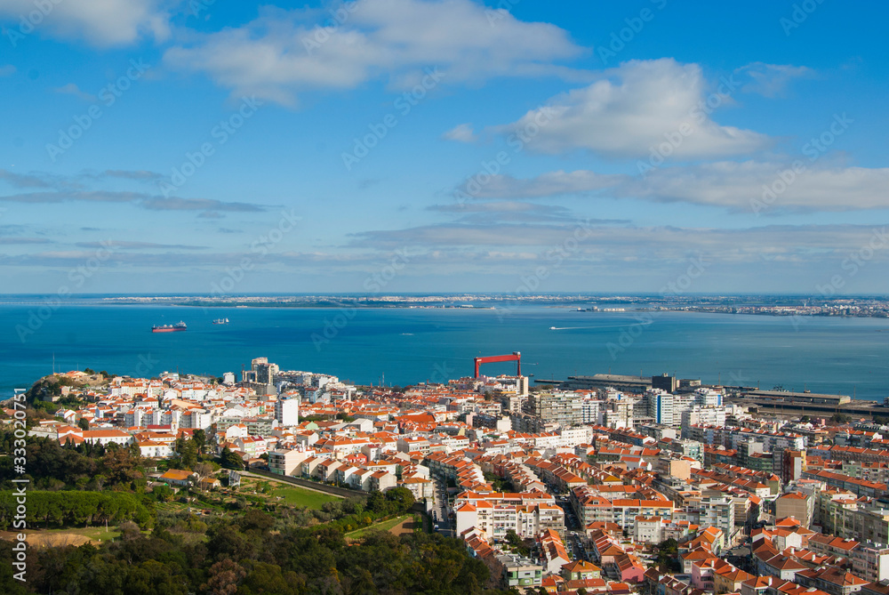 Portugal's coastline, top view on the city on a sunny day. Houses with orange roofs and sea on the horizon. 