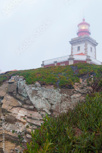 The lighthouse at Cape Cabo da Roca on a foggy day. A view of the rock and the lighthouse from bottom to top.