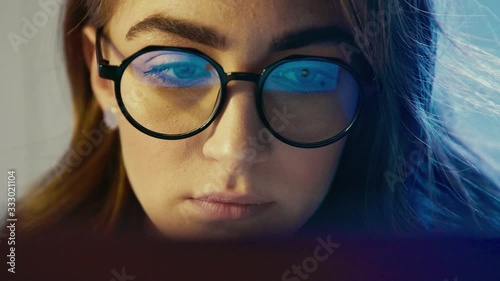 Close up view of businesswoman reflection of light glasses focused working Internet laptop tablet female eyes woman in glasses use internet at night Girl look at display touchscreen computer monitor