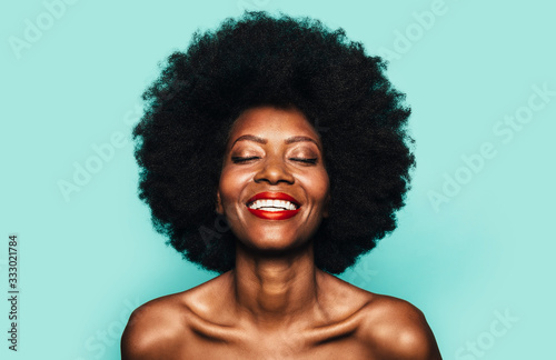 Topless Happy Afro Woman posing over blue background