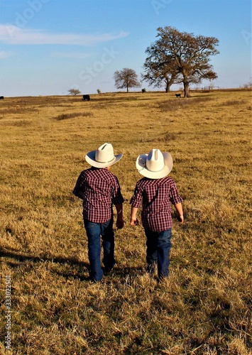 Two Little Cowboys Heading Out Across A Pasture in South Central Oklahoma to Check on the Calves